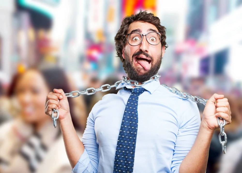 Mann zieht symbolisch eine Kette um seinen Hals enger als Sinnbild fuer das einengende Gefuehl der Angst