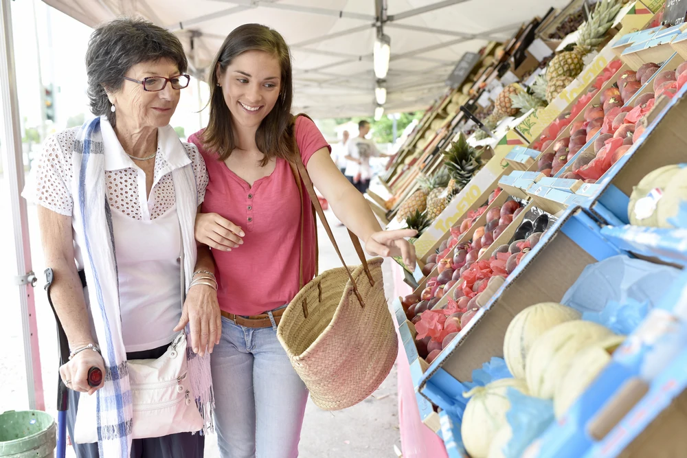 Zwei Frauen kaufen gemeinsam auf einem Obstmarkt ein