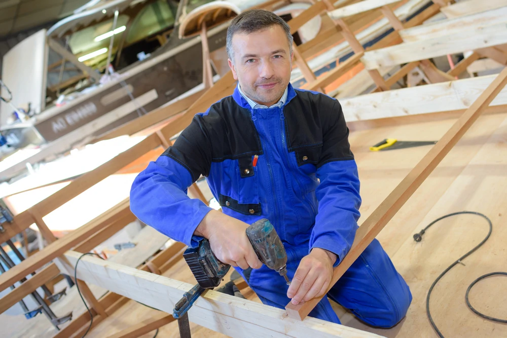 Konzentrierter Handwerker bei der Arbeit mit Holz in seiner Werkstatt